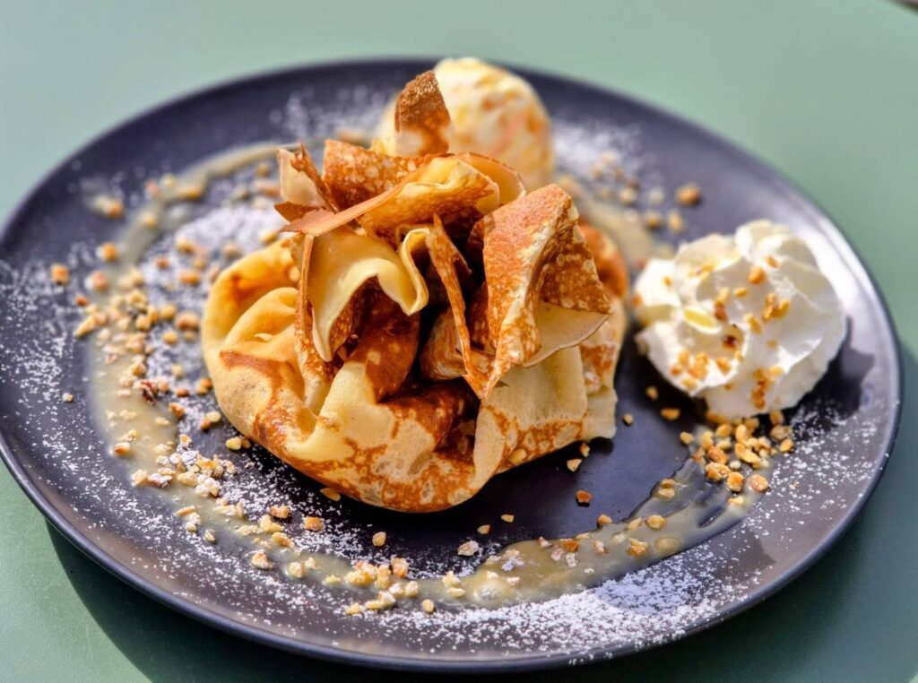 Ballotin de crêpe, crème de noisettes à la liqueur de poire, glace double crème, poires, chantilly et noisettes. 🥞🍐